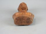 a figurine of a man sitting on top of a wooden block