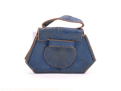 un sac à main bleu posé sur une surface blanche