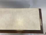 an antique wooden box with a marble top on a white background