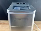 a close up of a small ice maker on a wooden table