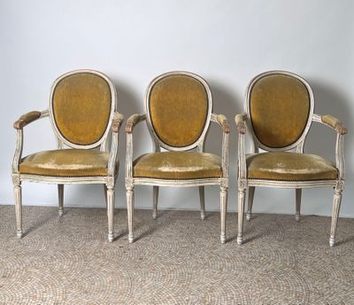 three chairs with yellow upholstered cushions are sitting against a wall