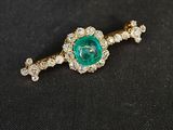 un gros plan sur une broche en forme de losange verte et blanche