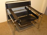 un fauteuil en cuir noir placé dans un coin de la pièce