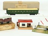 trois wagons de train miniature et une boîte sur laquelle est représenté un train