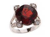 gros plan d'une bague avec une pierre rouge entourée de diamants