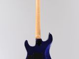 an electric guitar hanging from a string on a white wall