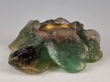 une bougie verte posée sur une table blanche