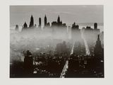 black and white photograph of a city skyline with fog in the air