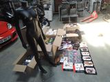 a black mannequin in a room with many boxes of magazines