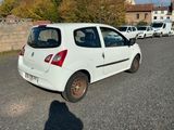 a small white car parked on the side of the road
