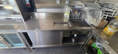a stainless steel kitchen with a sink and a refrigerator
