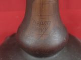 a brown vase with a black base sitting on a red surface