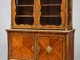une armoire ancienne en bois à deux portes, dont l'une est vitrée