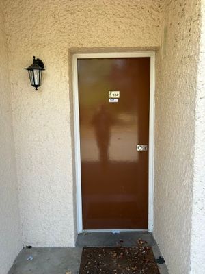 une porte marron et une porte marron sur un immeuble blanc