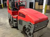 an image of a red road roller in a warehouse