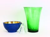un vase en verre vert et un bol bleu placés l'un à côté de l'autre