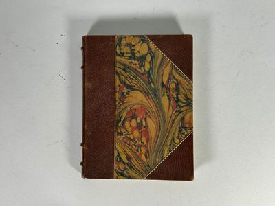 un vieux livre orné d'un motif floral, posé sur une surface blanche