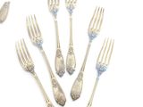 six forks and spoons are arranged in a circle on a white surface