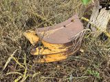 a rusted piece of wood in the middle of a field