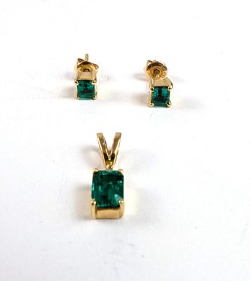 trois bijoux de couleur émeraude posés sur une surface blanche