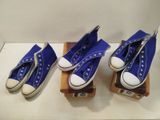 Trois paires de Converse bleues sont alignées sur un présentoir en bois