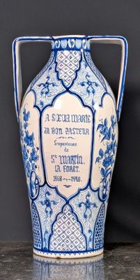 un vase bleu et blanc posé sur une table près d'un mur