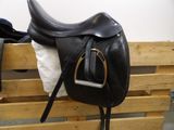 a black saddle and a white blanket on a wooden crate