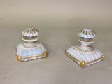 Deux figurines blanches et dorées sont posées sur une table