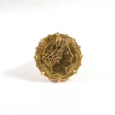 an image of a gold ring with a coin on it