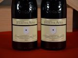 two bottles of wine sitting on a table next to each other