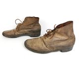 pair of brown leather boots with laces on them on a white surface