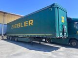 un camion vert garé devant un immeuble