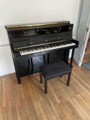 a piano in the corner of a room with wood floors
