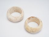 pair of white ceramic rings on a white surface with a hole in the middle