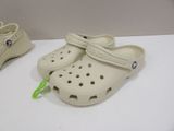 two pairs of crocs are sitting on a white table