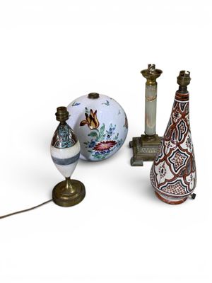 trois vases et une lampe posés sur une surface blanche