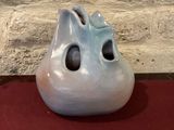 a white vase with a face on it sitting on a table