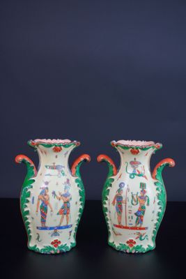 une paire de vases chinois posés sur une table noire, devant un fond sombre