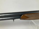 a shotgun with a wooden barrel and a wooden handle