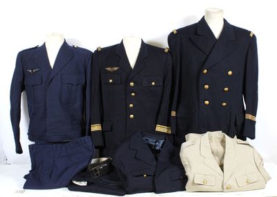 three men ' s military uniforms are displayed on a white surface