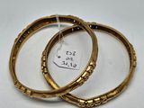 a pair of gold bangles with a price tag on them