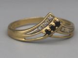 une image représentant une bague en or sertie de diamants noirs et blancs