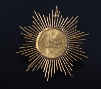 a close up of a gold medal on a black surface