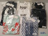 un grand nombre de t-shirts posés sur une table