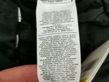 someone is holding a receipt in their pocket of a black jacket