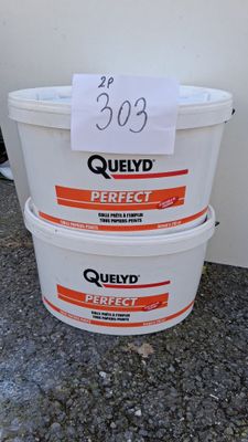trois seaux remplis de liquide posés par terre près d'un mur