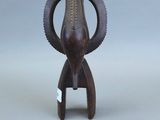une image représentant une petite statue d'éléphant en bois posée sur une surface grise