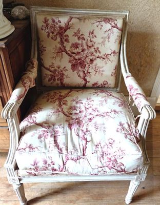 une chaise dont l'assise est recouverte d'un tissu à motifs floraux