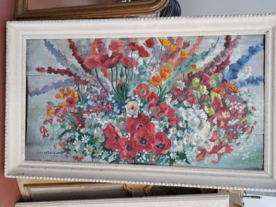 un tableau représentant des fleurs dans un vase posé sur une commode