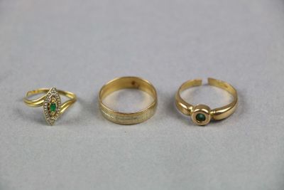 trois bagues en or et une bague sertie d'une pierre verte